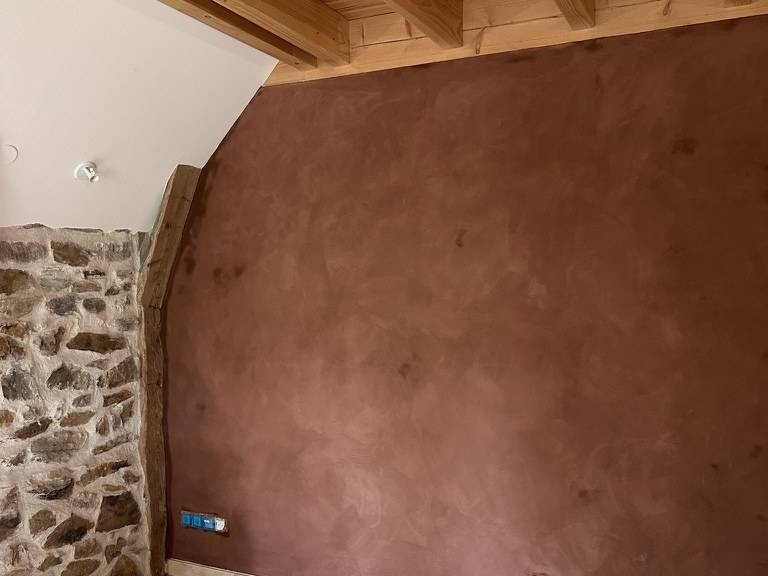 Mur intérieur en enduit mince à la chaux patiné, teinte terracotta profonde