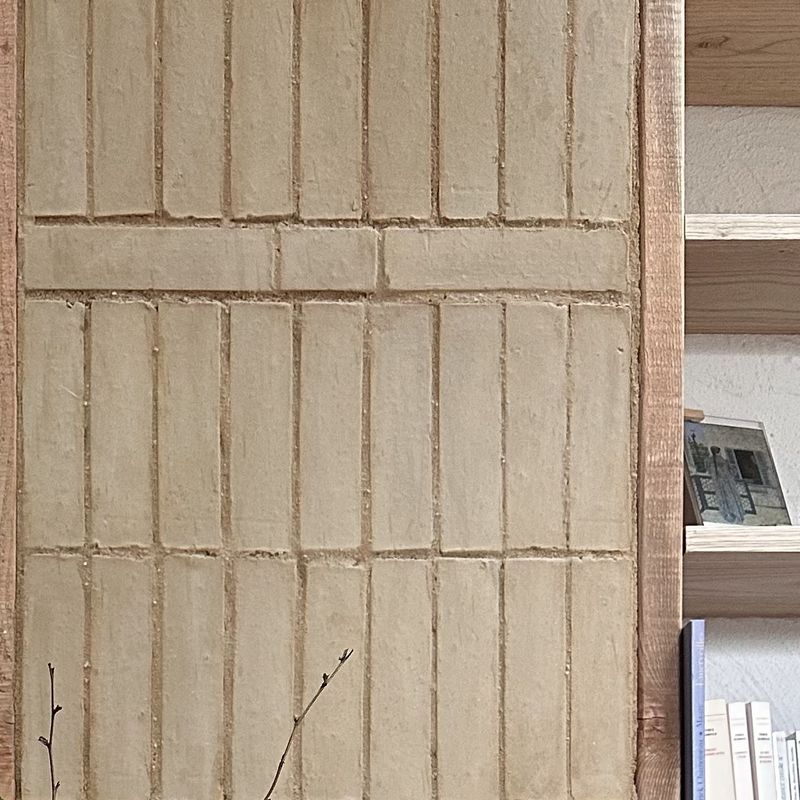 Macro d'un mur habillé de briques de terre crue posées en clayette verticale