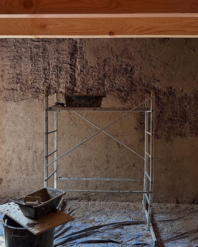 Mur en terre allégée à la texture brute, échafaudage devant