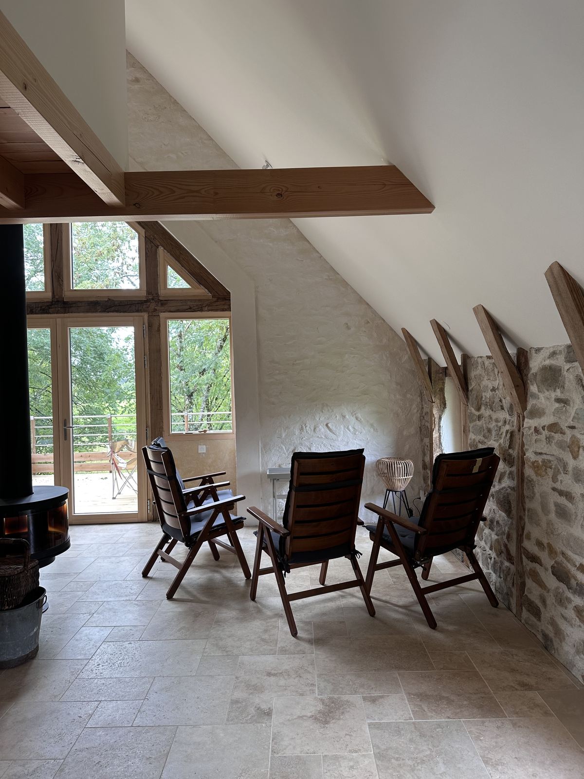 Pièce de vie avec poêle, murs en badigeon de chaux et pierre apparente