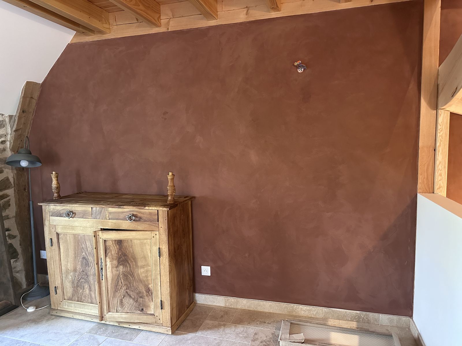Mur intérieur en enduit mince à la chaux patiné, teinte terracotta profonde